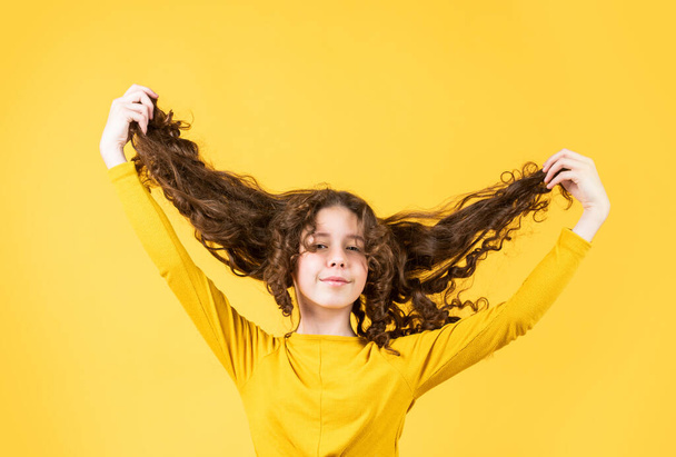being in funny mood. healthy and strong hair. good shampoo or lotion. hairdresser beauty salon. Strong and healthy hair concept. Small child long hair. kidding around. happy girl with long windy hair - Foto, Bild