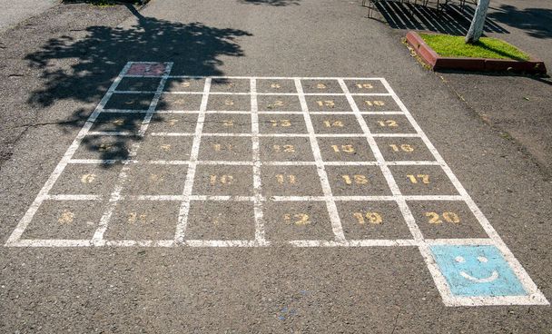 Kinderspiel zeichnet auf dem Bürgersteig mit Zahlen und Quadraten. - Foto, Bild