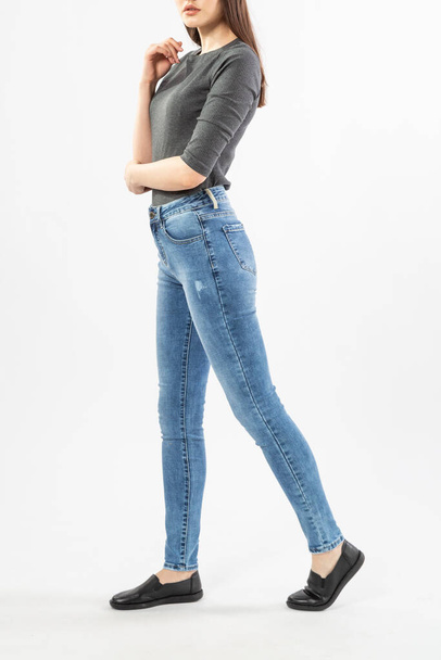 girl in jeans shows jeans on a white background close-up, blue jeans - Foto, afbeelding