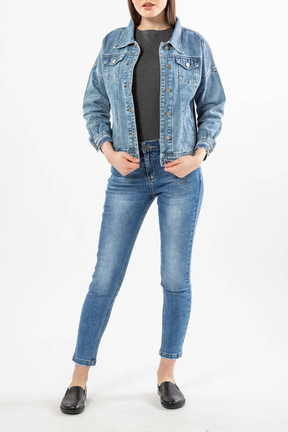 girl in a denim suit, denim jacket and trousers on a white background, blue jeans - Foto, afbeelding