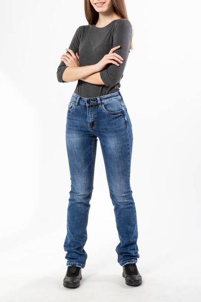 girl in jeans shows jeans on a white background close-up, blue jeans - Φωτογραφία, εικόνα