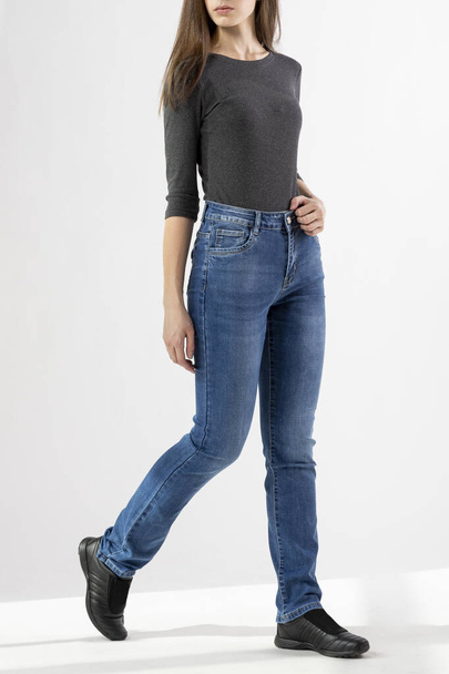 girl in jeans shows jeans on a white background close-up, blue jeans - Fotografie, Obrázek