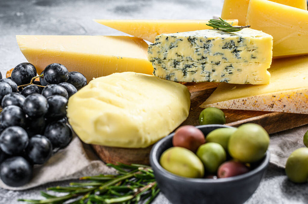 ナッツオリーブとブドウとチーズの異なる作品。おいしいお菓子を盛り合わせ。灰色の背景。トップ表示. - 写真・画像
