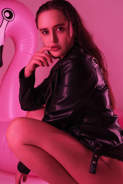 sexy girl in leather dress posing at the pink background - Photo, image