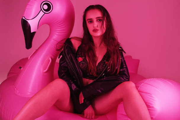 sexy girl in leather dress posing at the pink background - 写真・画像