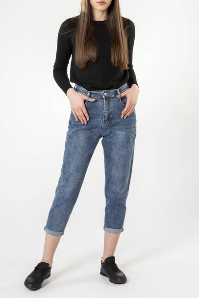 girl in jeans shows off jeans on white background close up, blue jeans - Фото, изображение