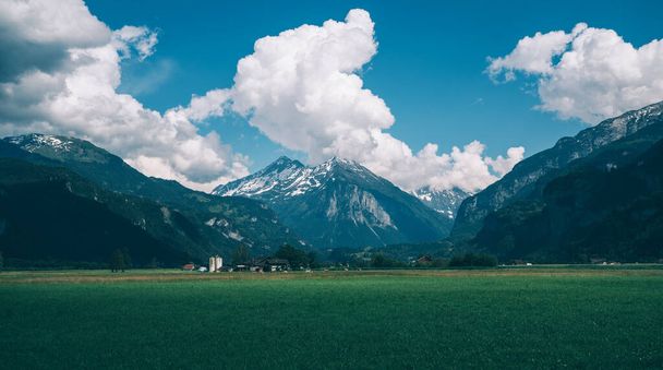 Green fields and famous Lauterbrunnen valley with high cliffs in background, Oberland, Switzerland, Europe. - Fotoğraf, Görsel