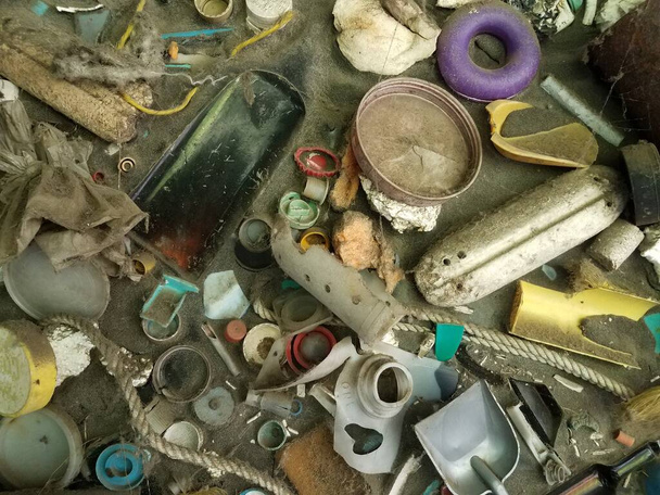 písek a různé plastové a jiné odpadky nalezené v oceánu nebo moři - Fotografie, Obrázek