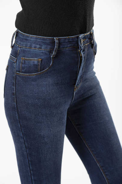 girl in blue jeans in front shows jeans on a white background close-up. - Foto, Bild