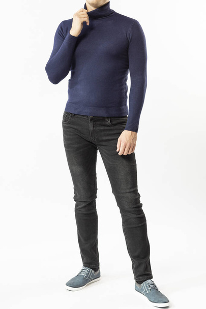 a man in a blue turtleneck and black jeans on a white background, a blue men's turtleneck close-up - 写真・画像