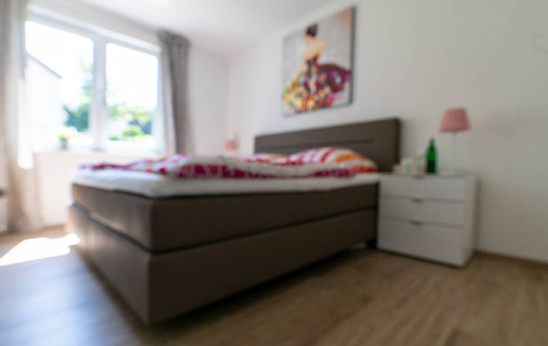 Dormitorio borroso con cama blanca y colorida
 - Foto, Imagen