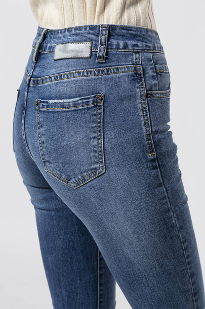 girl in jeans shows off jeans on white background close up, blue jeans - Φωτογραφία, εικόνα