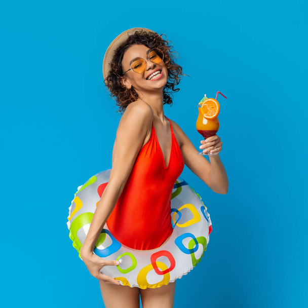 Strandparty-Stimmung. Schwarzes Mädchen im Badeanzug hält Sommercocktail und genießt die Feiertage - Foto, Bild