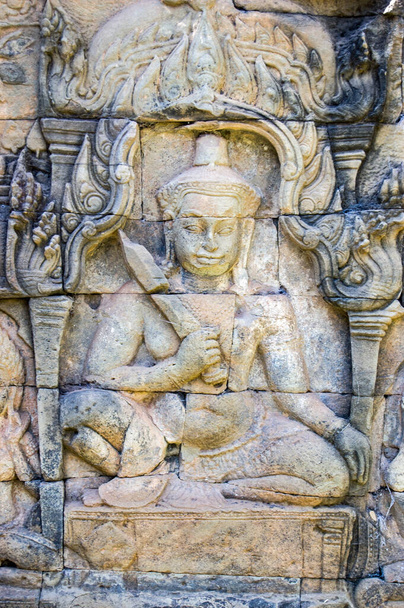 Egy démon, vagy hindu isten faragása, karddal a kezében. A Leper király terasza, Angkor Thom, Kambodzsa. - Fotó, kép