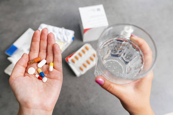woman Holding Pills and Glass of Water for medication - Photo, Image