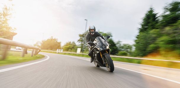 moto en la carretera en una curva con velocidad de movimiento en un recorrido en motocicleta. copyspace para su texto individual
. - Foto, Imagen