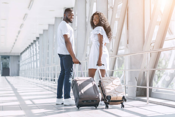 Reizen en huwelijksreis concept. Jong zwart paar poseren in de luchthaven voor vertrek - Foto, afbeelding