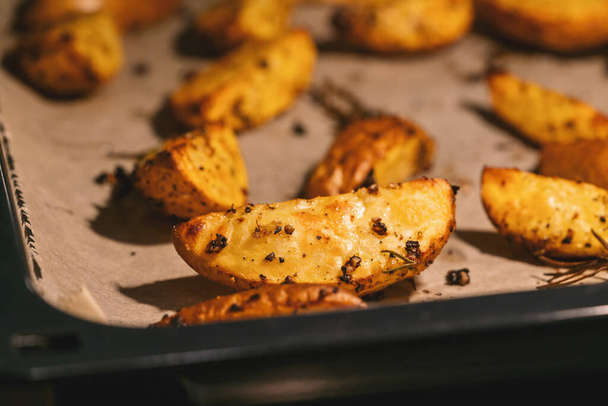 Cunei di patate al forno sulla teglia - verdure biologiche vegane fatte in casa cunei di patate vegetariane pasto snack
. - Foto, immagini