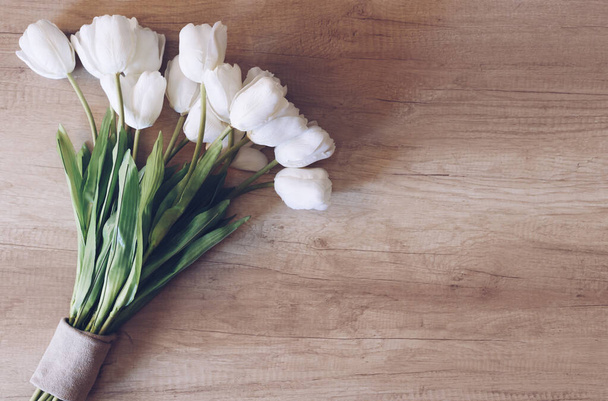 Beautiful tulips on white wooden background. Flat lay, top view, copy space. Table, petals. Close-up. - Zdjęcie, obraz