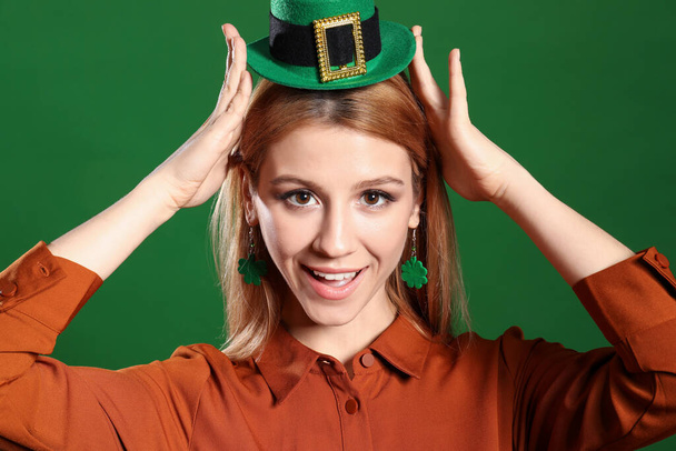 Young woman in leprechaun hat on green background. St. Patrick's Day celebration - Fotoğraf, Görsel