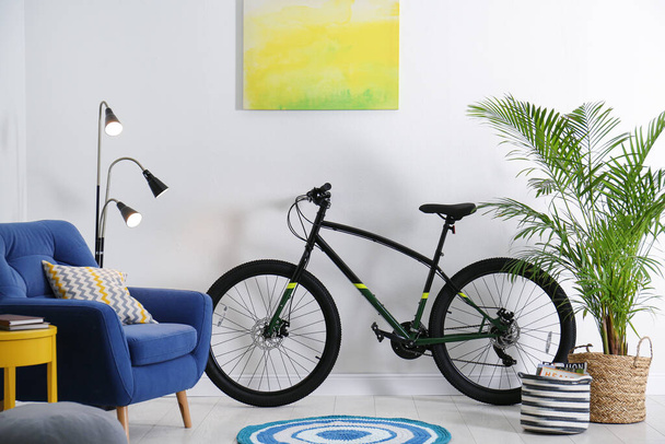 Modern bicycle and comfortable armchair in stylish living room interior - Foto, immagini