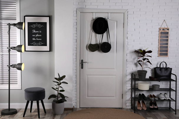 Hallway interior with stylish furniture, shoes and plants - Photo, image