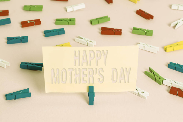 Fogalmi kézírás a Boldog Anyák Napjáról. Üzleti fotó kirakat ünnepelt tiszteletére az anyaság s befolyása a társadalomban Színes ruhacsap papírok üres emlékeztető rózsaszín padló iroda. - Fotó, kép