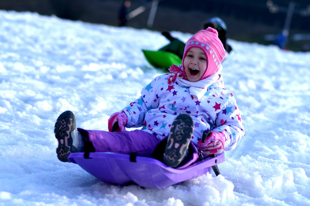 Gelukkig meisje rodelen, winter fun, sneeuw, familie rodelen - Foto, afbeelding