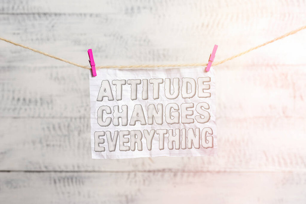 Handwriting text writing Attitude Changes Everything. Concept meaning Positive behavior achieve the business goal Clothesline clothespin rectangle shaped paper reminder white wood desk. - Photo, Image