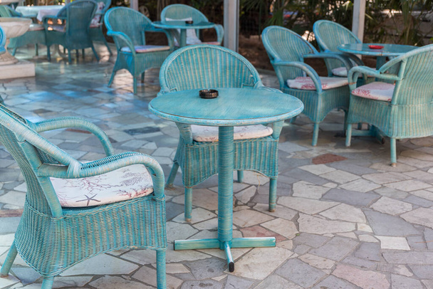 затишне вуличне кафе з бірюзовими столами та кріслами на відкритому повітрі обідня зона
 - Фото, зображення