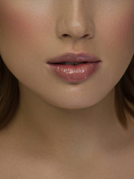 Sexual full lips. Natural gloss of lips and woman's skin. The mouth is closed. Increase in lips, cosmetology. Pink lips and long neck. Gentle pure skin and wavy blonde hair. - Φωτογραφία, εικόνα