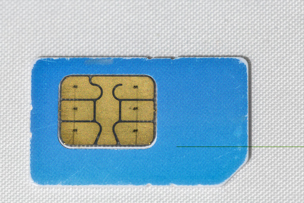 gebruikte gekrast blauwe mobiele telefoon simkaart macro op wit - Foto, afbeelding