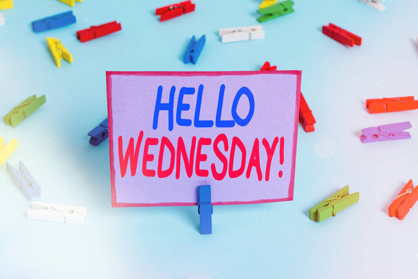 Writing note showing Hello Wednesday. Business photo showcasing it is a good day when you reach in the middle of the week Colored clothespin papers empty reminder blue floor officepin. - Photo, Image