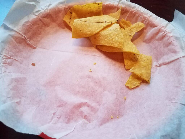 een bijna volledig lege mand van tortilla chips - Foto, afbeelding