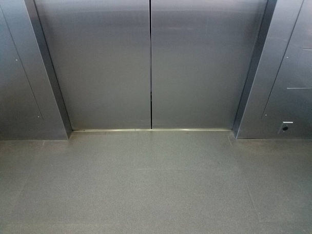 внутри лифта с блестящими металлическими дверями
 - Фото, изображение