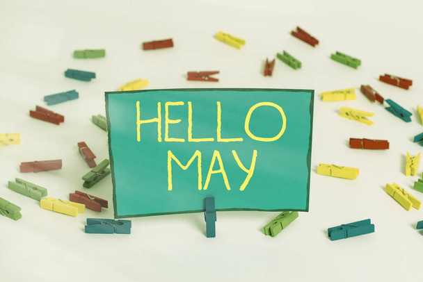 Szövegírási szöveg Hello May. Üzleti koncepció az év ötödik hónapjának inspirációval és bátorítással való megszólítására Színes ruhaszárító papírok üres emlékeztető fehér padló háttér iroda. - Fotó, kép