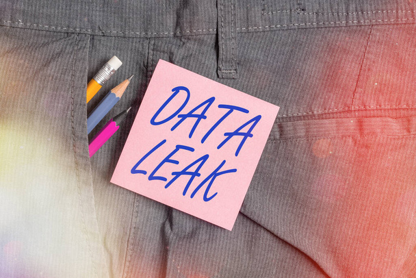 Conceptual hand writing showing Data Leak. Business photo text released illegal transmission of data from a company externally Writing equipment and pink note paper inside pocket of trousers. - Photo, Image
