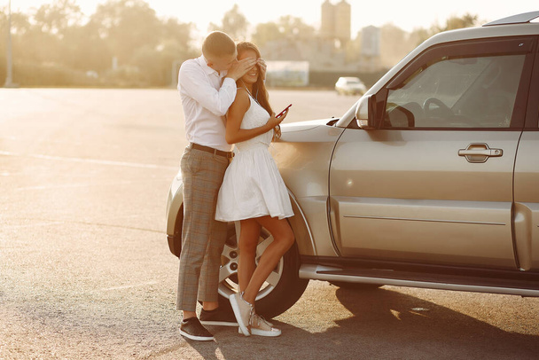Beautiful couple spend time in a summer park near a car - Photo, image