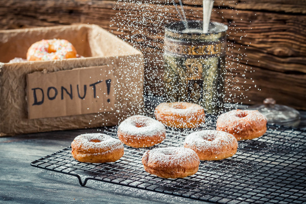 Icing sugar falling on fresh donuts - Foto, Bild