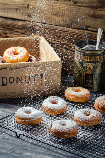 Closeup of falling icing sugar on fresh donuts - Fotografie, Obrázek