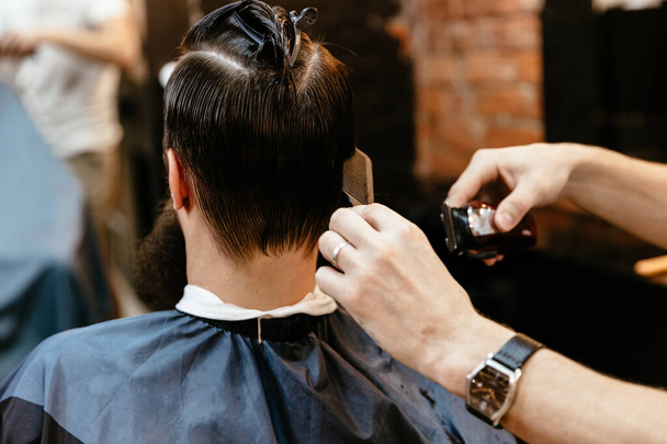 Barbershop Close-up of barber holds clip-on hair clipper - Foto, Imagen