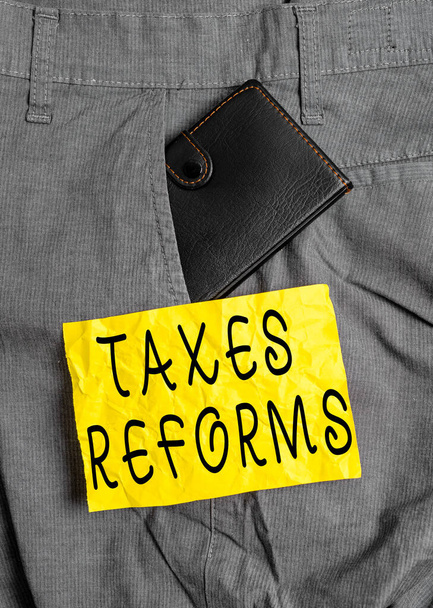 単語のテキスト税改革を書く。より効率的なプロセスで収集した税金を管理するためのビジネスコンセプト表記紙の近くの男のズボンフロントポケット内の小さな財布. - 写真・画像