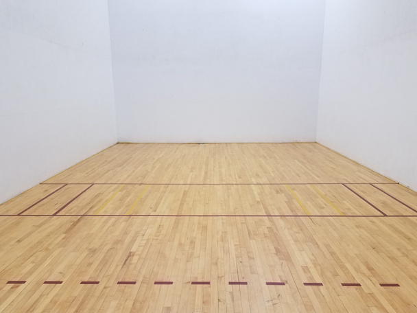 piso de madeira em quadra de raquete com paredes brancas
 - Foto, Imagem