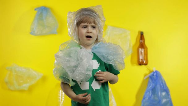 Meisje vrijwilliger in plastic pakjes om haar nek en hoofd. Verminderen van plastic vervuiling. Bewaar ecologie - Foto, afbeelding