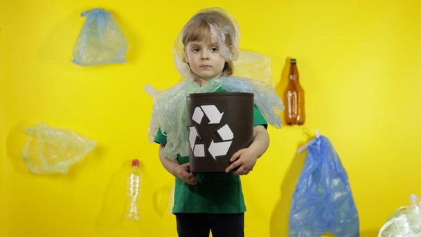 Mädchen in Plastikverpackungen an Hals und Kopf. Verringerung der Plastikverschmutzung. Ökologie retten - Foto, Bild