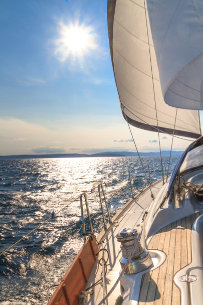 Yacht naviguant vers le coucher du soleil sur la mer bleue
 - Photo, image