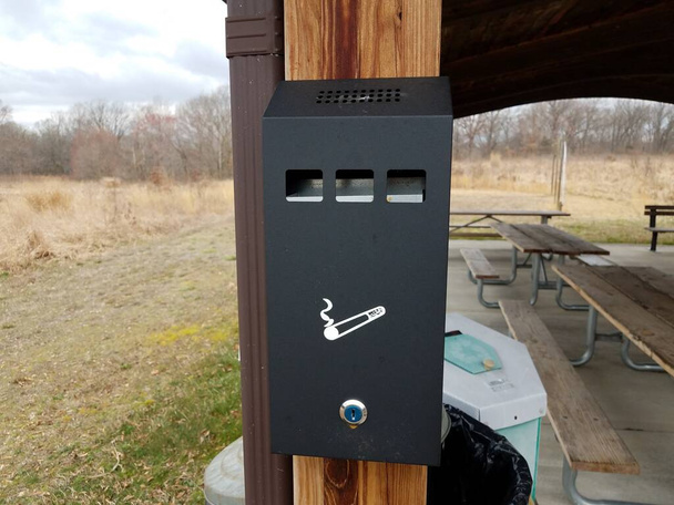 colillas de cigarrillos de metal caja de eliminación o contenedor en el poste de madera
 - Foto, Imagen