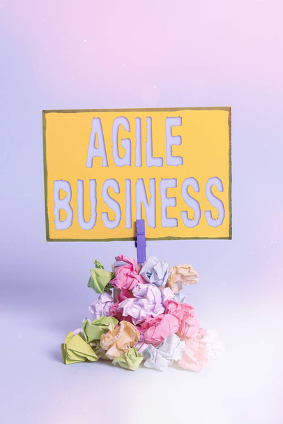 Text sign showing Agile Business. Conceptual photo capability of adjusting quickly to the market s is trend Reminder pile colored crumpled paper clothespin reminder blue background. - Photo, Image
