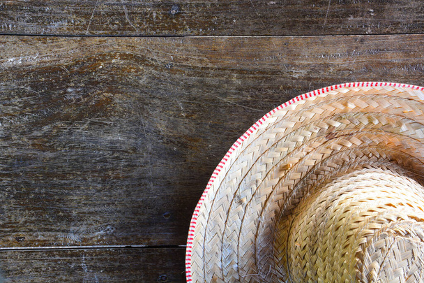 Eski ahşap arka planda örülmüş bambudan yapılmış yarım çizgili çiftçi şapkası, kopyalama alanı. - Fotoğraf, Görsel