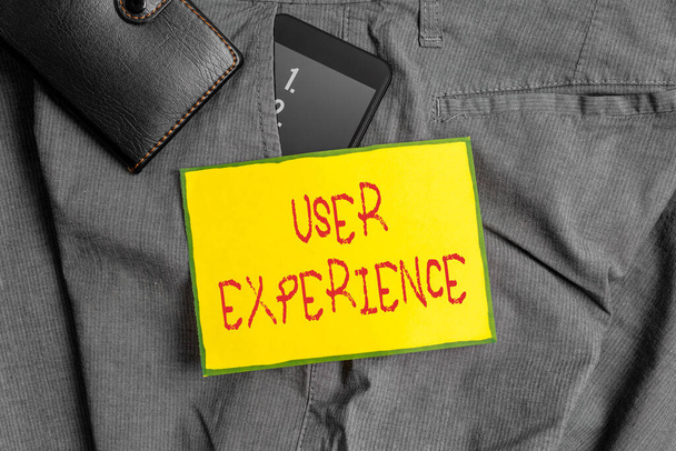 Conceptual hand writing showing User Experience. Business photo showcasing how an individual reacts and feels after using a specific product Smartphone device inside trousers front pocket with wallet. - Photo, Image